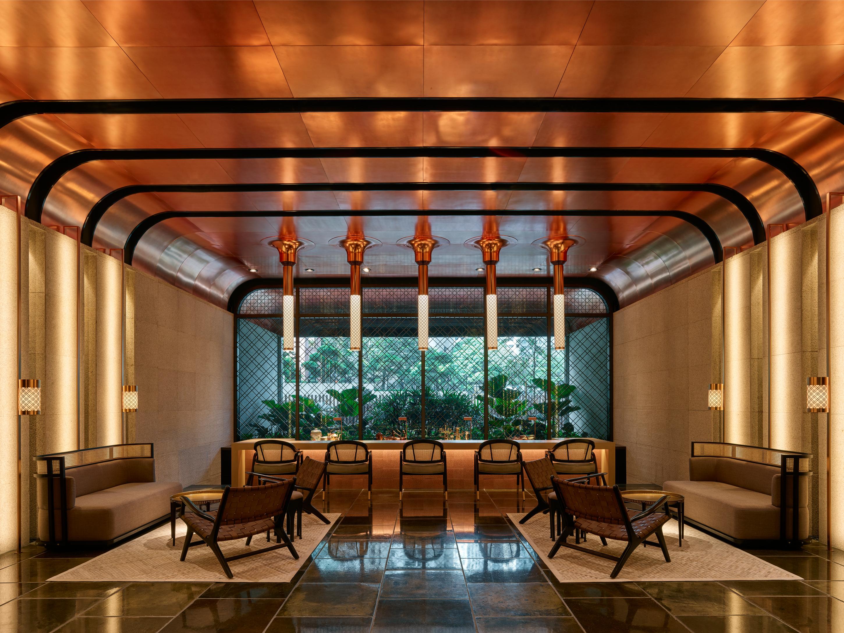 The Ruma Hotel And Residences Kuala Lumpur Exterior photo The image shows a stylish interior space with a modern and elegant design. The walls have a sleek, warm-toned finish, and there are large windows that provide natural light. The ceiling features striking architectural lines, likely in a metallic mate